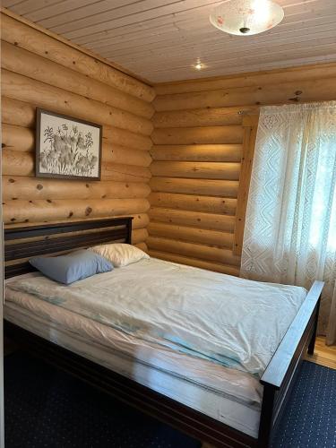 a bedroom with a bed in a log cabin at Villa Ossa in Tervola