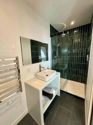 une salle de bain avec un lavabo et une douche dans l'établissement Chez Alice - 100m de la plage, à Bénodet