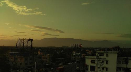 a view of a city with mountains in the background at Phoenix Lodge in Siliguri