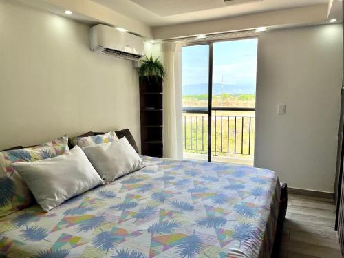 a bedroom with a bed with a view of a balcony at Lujoso apartamento en la ciudad de Neiva-Huila-T in Neiva