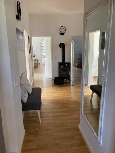 a living room with a wood stove and a mirror at FeWo Villa Haase in Ostorfer Hals