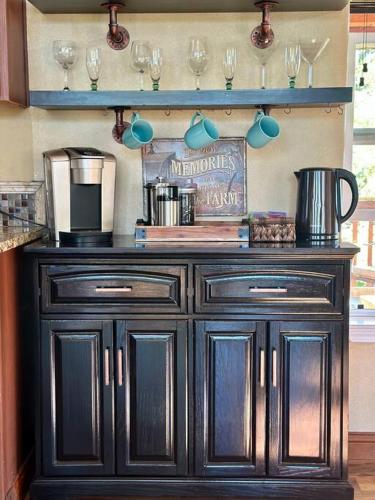 a black cabinet with wine glasses on a wall at Cascade Sunset House - Crater Lake Adventures! in Eagle Point