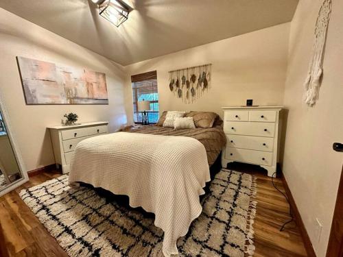 a bedroom with a bed and a dresser at Cascade Sunset House - Crater Lake Adventures! in Eagle Point