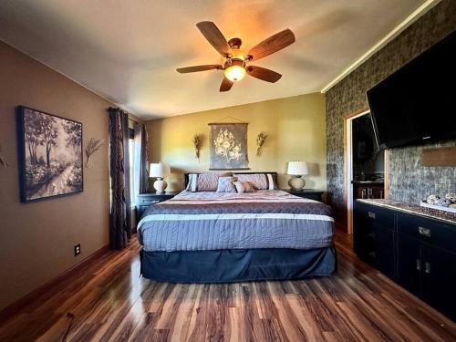 a bedroom with a bed with a ceiling fan at Cascade Sunset House - Crater Lake Adventures! in Eagle Point