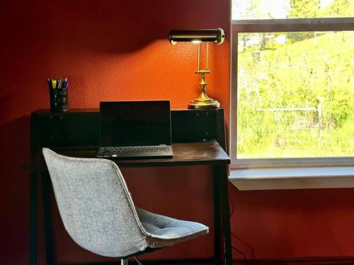a desk with a laptop and a chair next to a window at Cascade Sunset House - Crater Lake Adventures! in Eagle Point