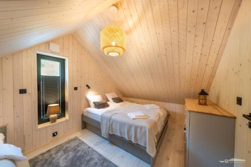 a bedroom with a bed in a wooden cabin at Mucharskie Zacisze in Zagórze