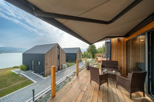 a house with a deck with a view of the water at Mucharskie Zacisze in Zagórze