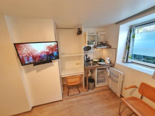 a small room with a television on a wall at Aparthotel B & L in Bremen