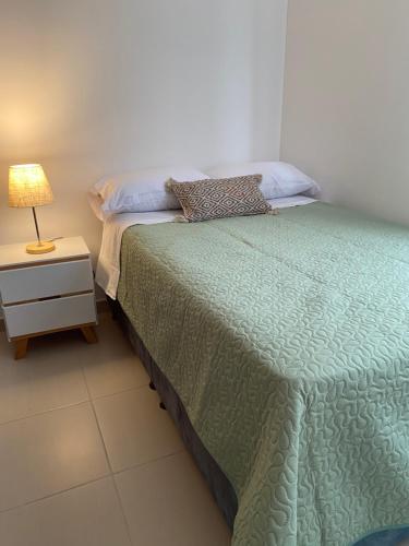 a bedroom with a bed and a lamp on a night stand at Apartamento en Floridablanca Santander in Loma Mesa de Ruitoque