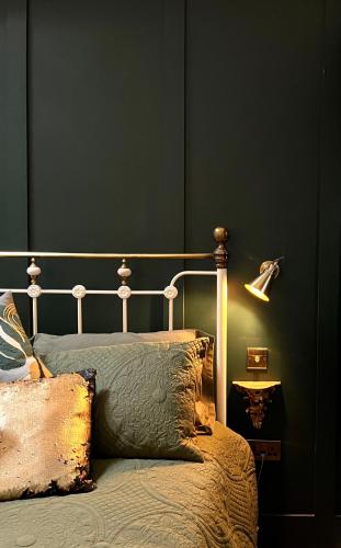 a bedroom with a bed with a green wall at Dinmont Cottage in Dalston