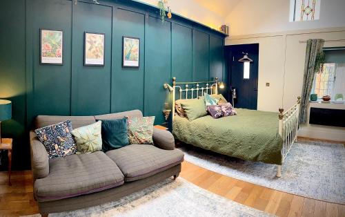 a living room with a couch and a bed at Dinmont Cottage in Dalston