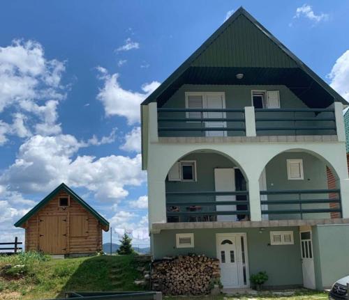 a house with a gambrel roof and a barn at Montenegro High Mountain Apartment in Žabljak