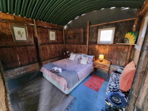 a bedroom with a bed in a wooden cabin at Protea Lodge - Glamping in the Karoo in Barrydale