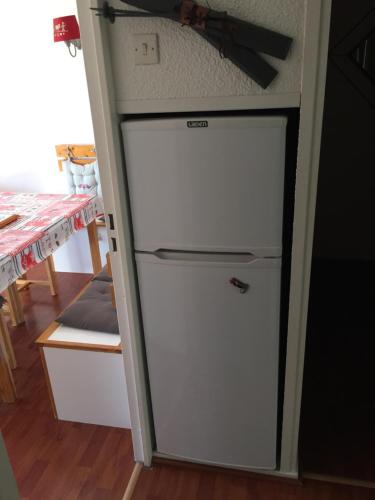 - un petit réfrigérateur blanc dans une cuisine à côté d'une table dans l'établissement La montagnarde, à Villarembert