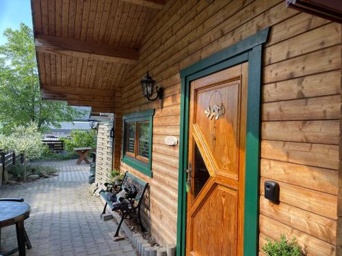 a wooden house with a door and a patio at Ferienhäuser an den Orgelpfeifen Scheibenberg in Scheibenberg