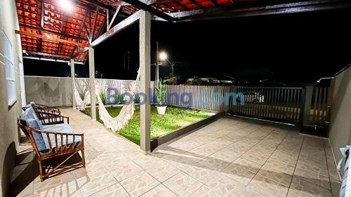 a porch with two chairs and a fence at night at Casa Sol da Manhã - Piscina aquecida com hidromassagem - 300m da praia in Guaratuba