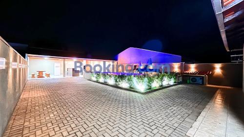 a building with lights on the side of it at night at Casa Sol da Manhã - Piscina aquecida com hidromassagem - 300m da praia in Guaratuba