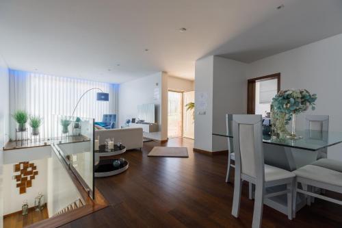 a dining room and living room with a table and chairs at Deluxe Villa Home, Peace & Spa in Vila do Conde
