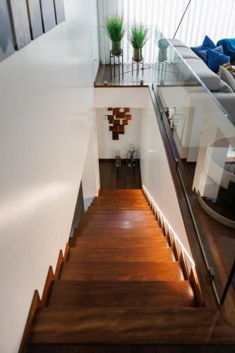 a staircase with wooden floors and a glass railing at Deluxe Villa Home, Peace & Spa in Vila do Conde