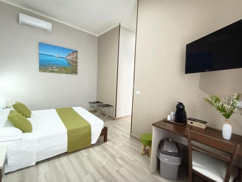 a hotel room with a bed and a flat screen tv at Domos La Corte Ghibellina in Iglesias