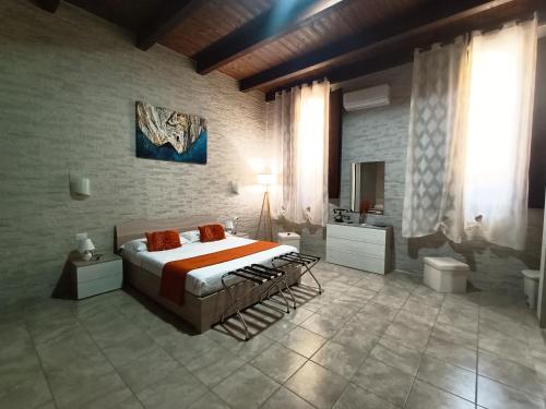 a bedroom with a large bed and a bathroom at Domos La Corte Ghibellina in Iglesias