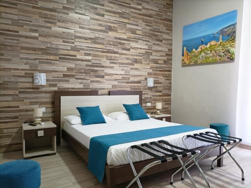 a bedroom with a bed and a brick wall at Domos La Corte Ghibellina in Iglesias