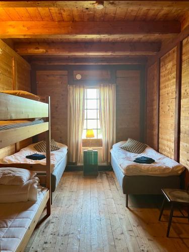 a bedroom with two bunk beds and a window at Humletorkan Vandrarhem in Näsum