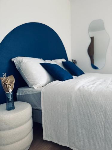 a bedroom with a bed with blue and white pillows at Plaisirs Normands in Saint-Julien-de-Mailloc