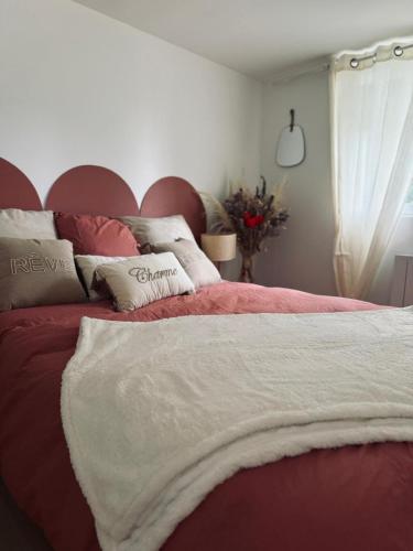 a bedroom with a bed with a red and white blanket at Plaisirs Normands in Saint-Julien-de-Mailloc