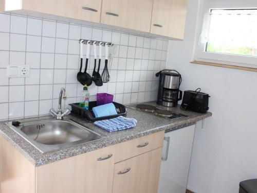 a kitchen with a sink and a counter with utensils at Bungalow Oberspreewald 5 in Ressen