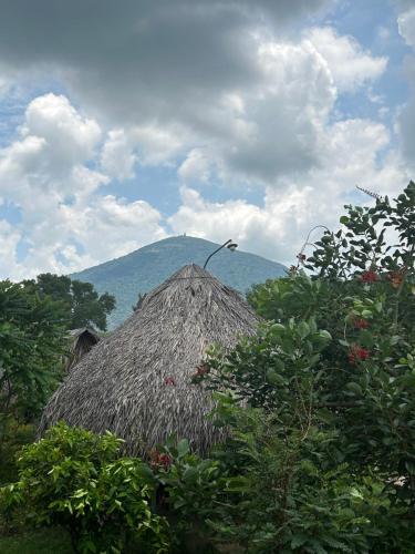 a straw hut with a mountain in the background at Huong Sen Garden lodge in Xóm Bãi Trại