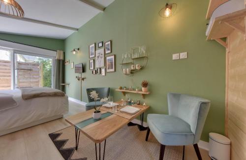 a room with a bed and a table and chairs at Entre Terre & Mer SPA in Sainte-Croix-Grand-Tonne