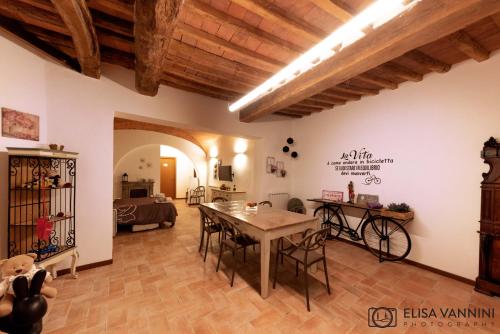 a large living room with a table and a bike at Il Gatto e La Volpe in Terricciola