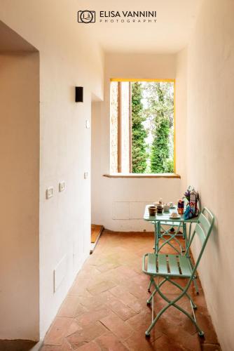 a green chair in a room with a table at Il Gatto e La Volpe in Terricciola