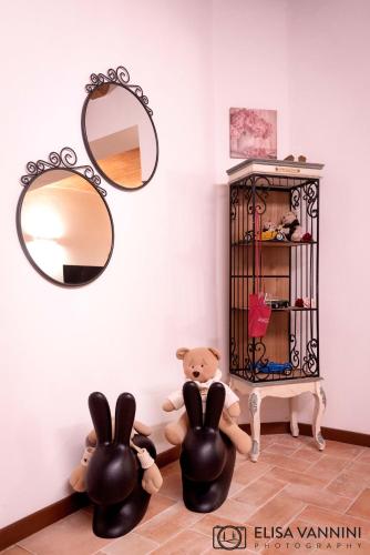 a room with a mirror and a shelf with stuffed animals at Il Gatto e La Volpe in Terricciola