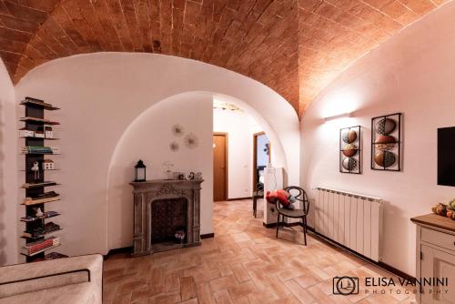 a living room with a fireplace and a wooden ceiling at Il Gatto e La Volpe in Terricciola