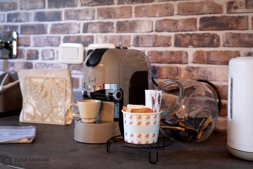 a coffee maker sitting on a counter with a cup of coffee at Il Gatto e La Volpe in Terricciola