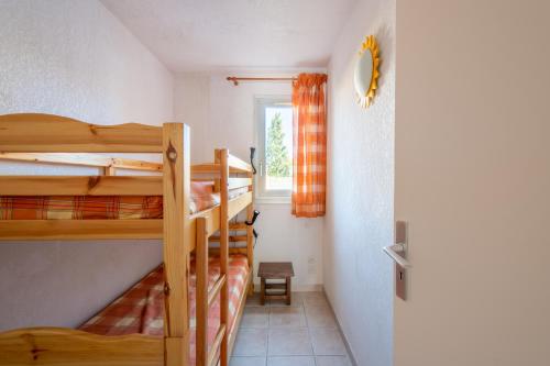a room with two bunk beds and a window at Le Brise Marine - Terrasse - Plage - Piscine - Parking in Cap d'Agde