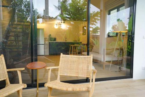 パンガン島にあるDani Villa's Studio Houseの椅子2脚とテーブル1台と窓のある部屋