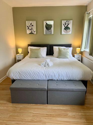a bed in a bedroom with two pictures on the wall at The Olive House - 4 Bedroom, Sleeps 8, Contractors Welcome in Middlesbrough