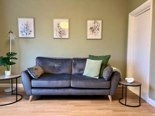 a blue couch in a living room with two tables at The Olive House - 4 Bedroom, Sleeps 8, Contractors Welcome in Middlesbrough