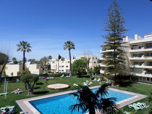 a large swimming pool in front of a building at Parque Mourabel Oasis Village & Pe do Lago in Vilamoura
