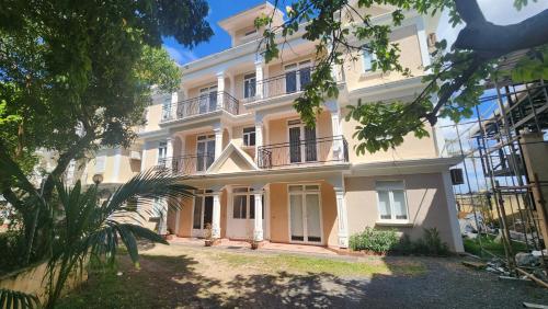 a large white building with a balcony at 2 bedroom apartment in Bain Boeuf in Cap Malheureux