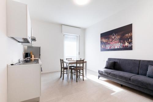 a kitchen and a living room with a couch and a table at Residence Signoria degli Scaligeri in Verona