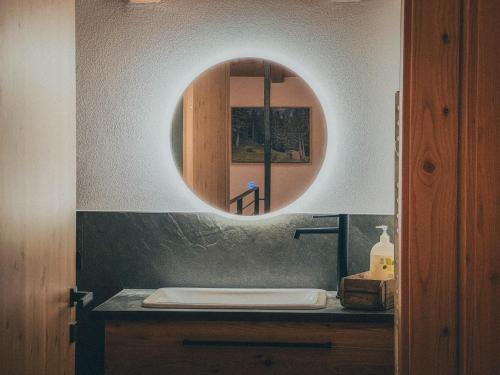 ein Badezimmer mit Waschbecken und Spiegel in der Unterkunft Chalet Astra, Whirlpool & Sauna in St. Pankraz