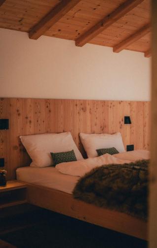 two beds in a room with wooden walls and ceilings at Chalet Astra, Whirlpool & Sauna in San Pancrazio dʼUltimo