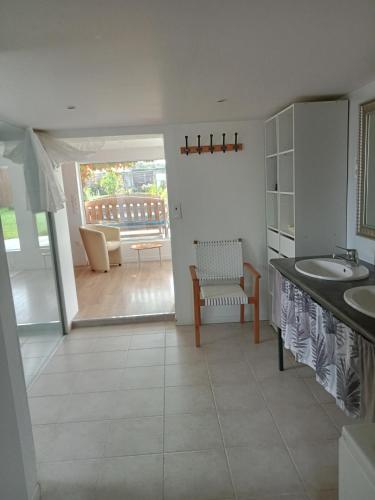 a bathroom with two sinks and a table and a chair at Grand studio tout équipé in Ploërmel