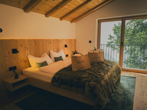 ein Schlafzimmer mit einem Bett und einem großen Fenster in der Unterkunft Chalet Astra, Whirlpool & Sauna in St. Pankraz