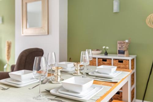 a dining room table with white dishes and wine glasses at 3 bed home in Wollaton, Nottingham in Chilwell