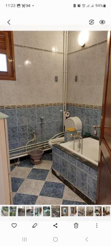 a bathroom with a tub and a toilet and a bath tub at Demeure coup de cœur in LʼAgha